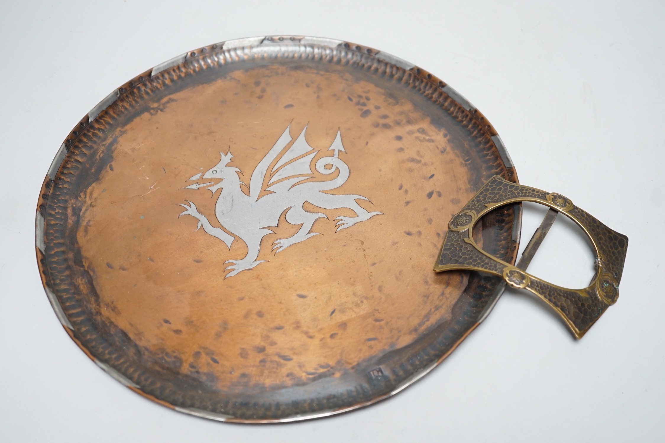 Paul Gillis. An Arts & Crafts copper tray and an Arts & Crafts buckle, tray 28cm diameter
